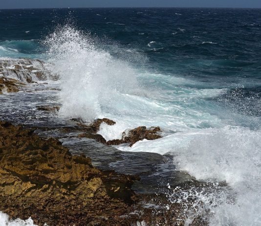 Weer op Curacao: Altijd warm en zonnig Zonnig strand op Curaçao met blauwe lucht en passaatwinden